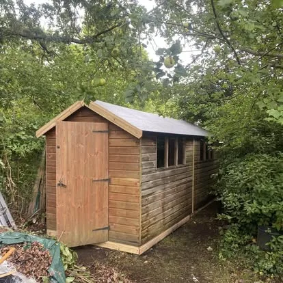 Timber garden shed after door, wall and roof restoration work