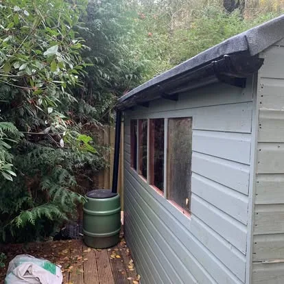 Painted shed after timber frame repairs and guttering installation