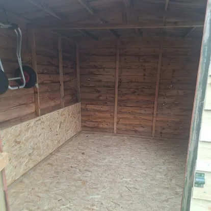 Interior of a timber shed after its floor and lower wall section were repaired