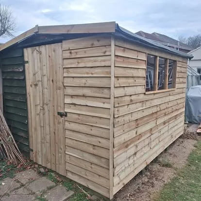 Garden shed with a rebuilt timber wall, renewed corner and replacement boarded door