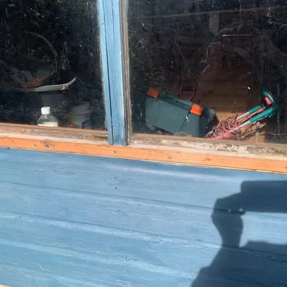 New timber fitted below the window of a painted garden shed