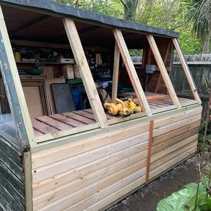 Sloping potting-shed windows during reconstruction with new timber frames
